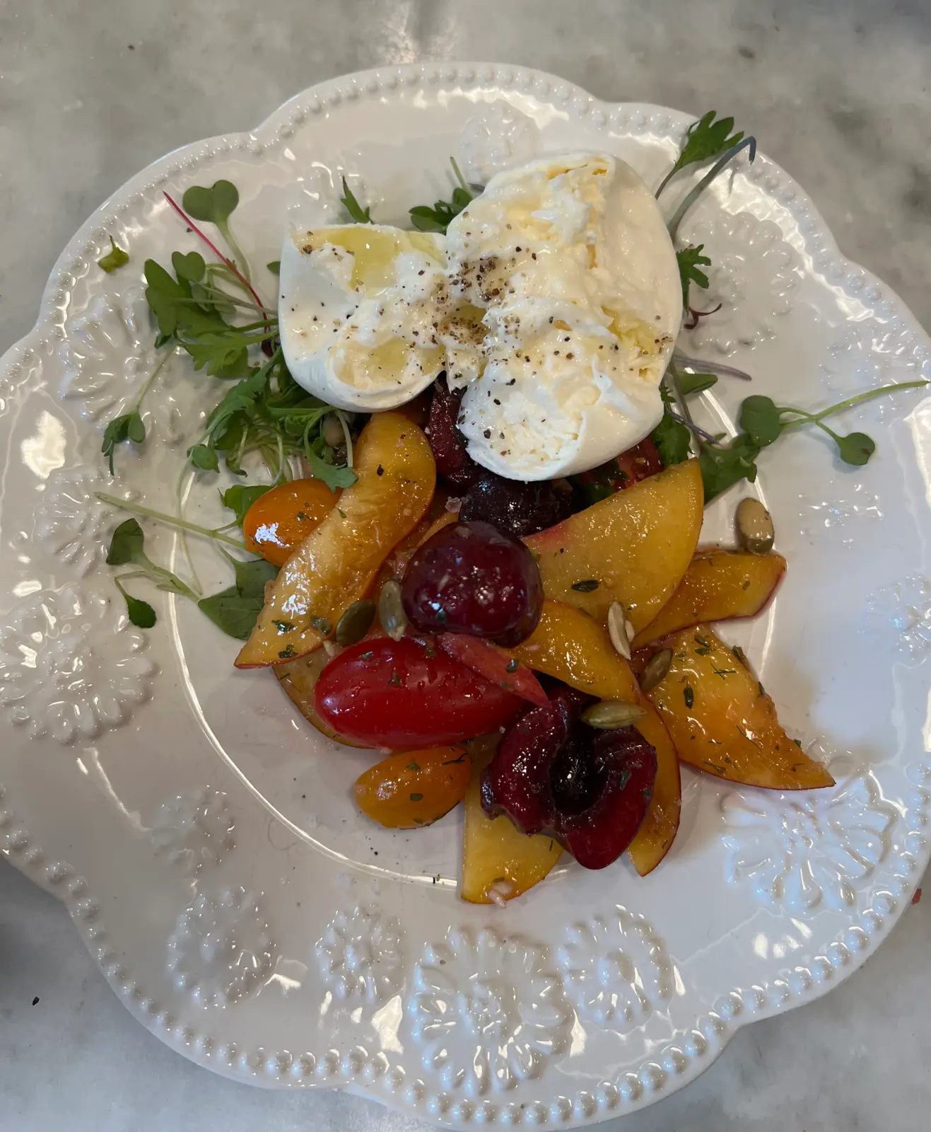 Peach salad with creamy cheese, mixed tomatoes and green herbs.